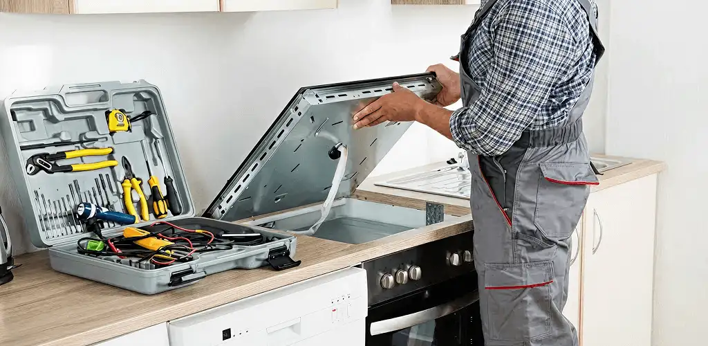 Handyman repairing a cooktop and checking wiring connections in Staten Island, NY