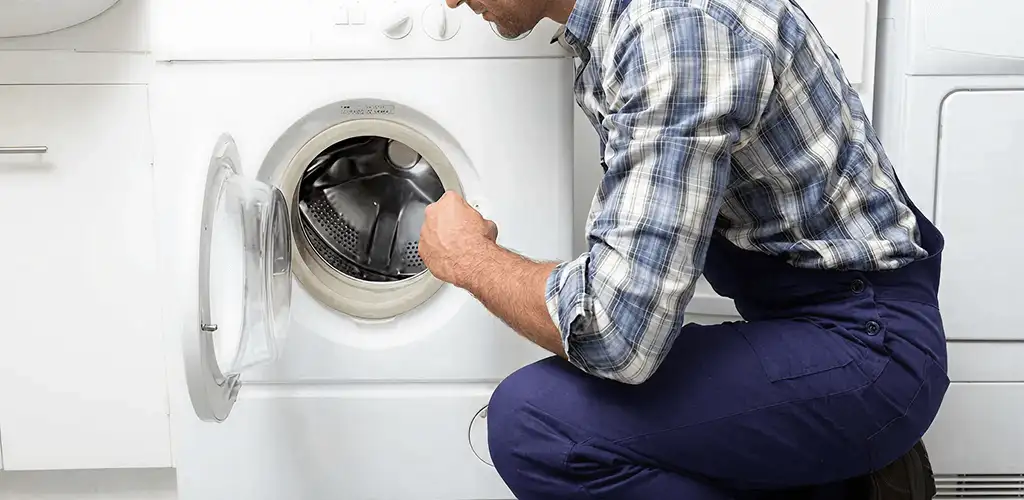 Handyman inspecting a dryer drum and internal parts for repair in Staten Island, NY