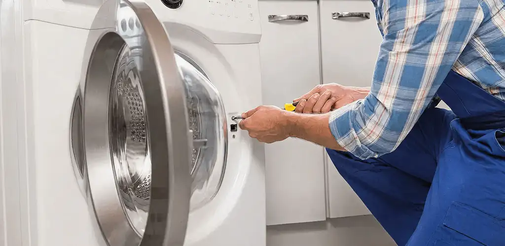 Handyman repairing a clothes dryer and checking electrical connections in Staten Island, NY