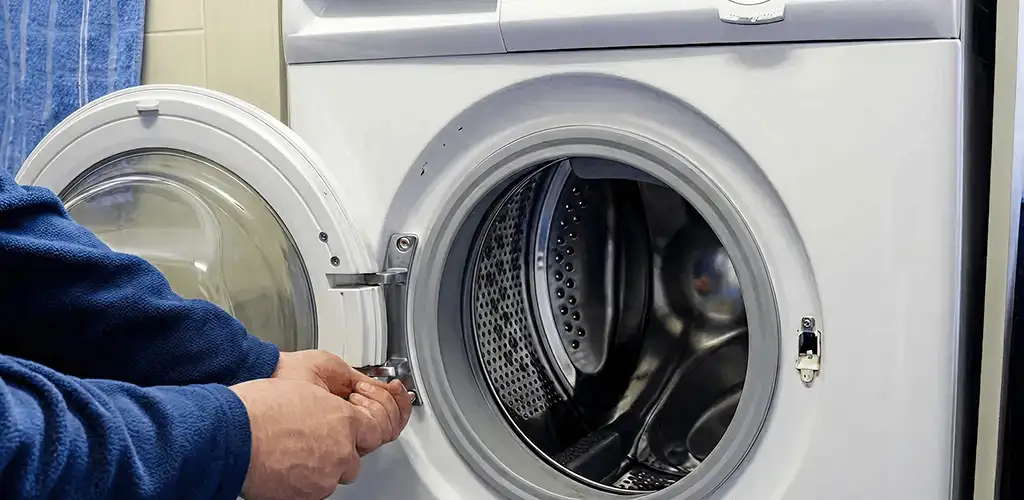 Washing machine repair handyman checking a front-load washer door and latch in Staten Island, NY
