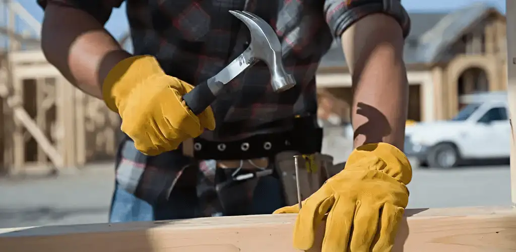 Handyman fixing wood trim with a hammer for home repairs in Staten Island, NY