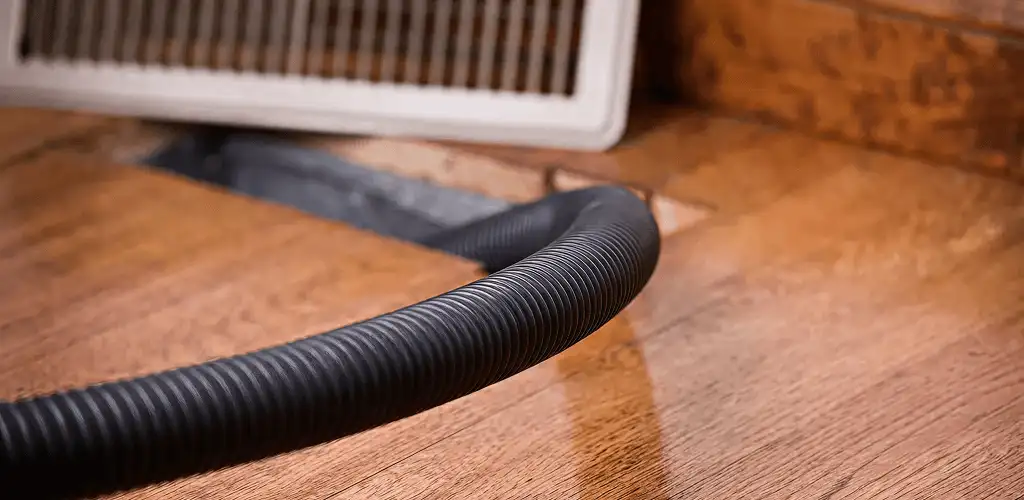 Air duct cleaning hose inserted into a floor vent for ductwork cleaning in Staten Island, NY