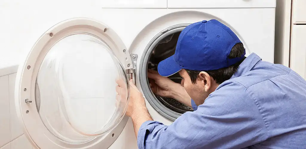 Washing machine repair handyman inspecting a front-load washer drum in Staten Island, NY